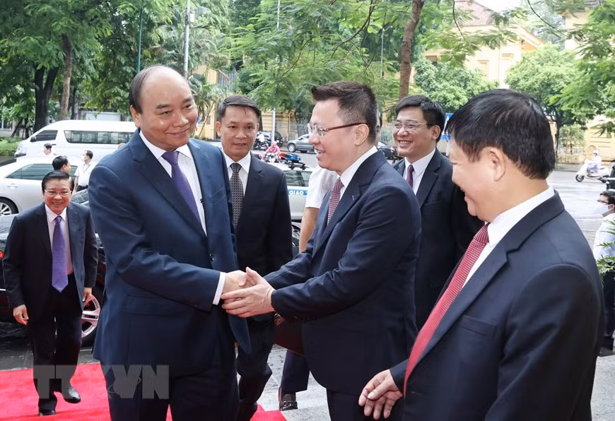 El secretario del Comité partidista y subdirector general de la VNA, Le Quoc Minh, da la bienvenida al primer ministro Nguyen Xuan Phuc a su llegada al acto conmemorativo del aniversario 75 de la fundación de esta agencia (Foto: VNA)