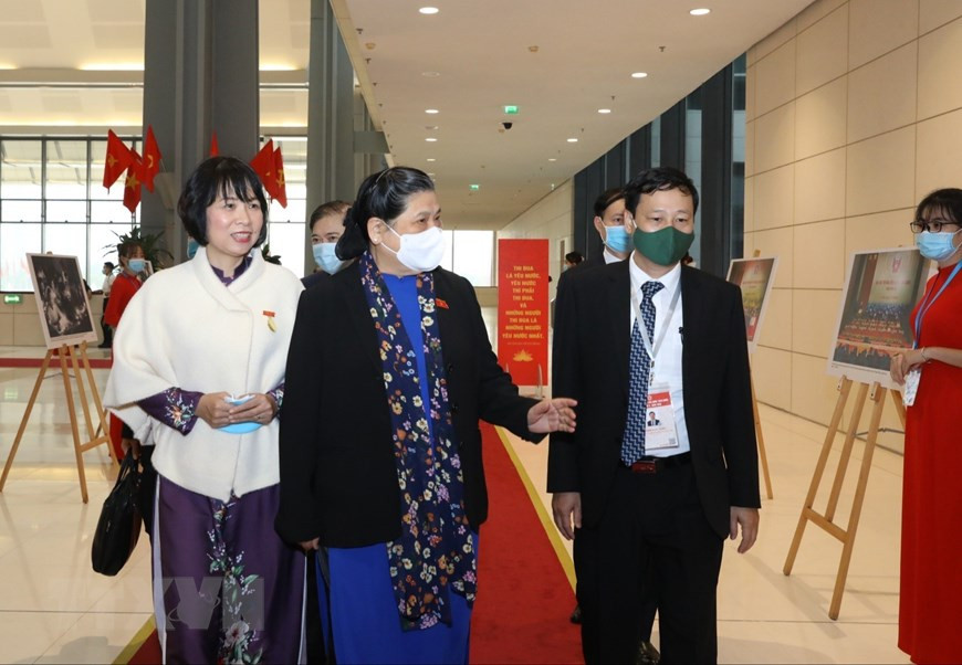 Dirigentes de la Agencia Vietnamita de Noticias (VNA) presentan a la vicepresidenta de la Asamblea Nacional, Tong Thi Phong, las fotos de la VNA exhibidas en el evento. (Fuente: VNA)