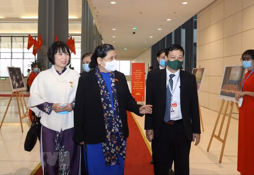 Dirigentes de la Agencia Vietnamita de Noticias (VNA) presentan a la vicepresidenta de la Asamblea Nacional, Tong Thi Phong, las fotos de la VNA exhibidas en el evento. (Fuente: VNA)