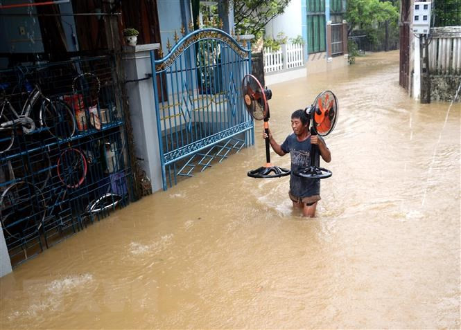 Un residente de Quang Ngai trasladó productos de necesidad básica debido a las riadas (Foto: VNA)