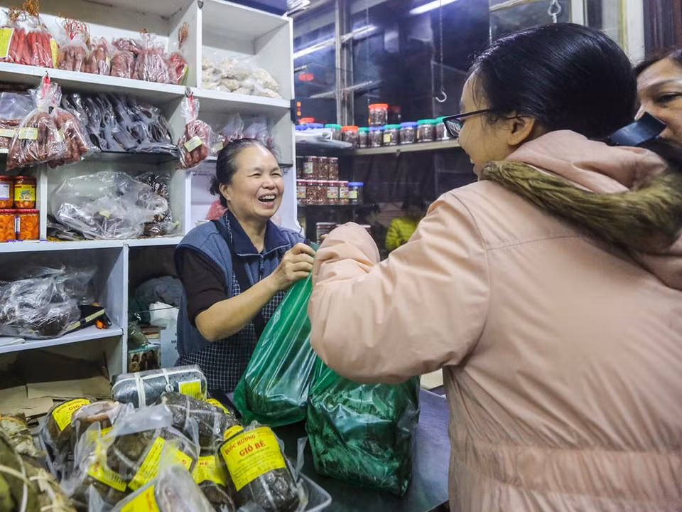 Solo más de una hora después de abrir la tienda, cerca de 500 Banh Chung (pasteles cuadrados de arroz glutinoso, cerdo y guisantes envueltos en hojas de banano) y Gio Cha (jamón o salchicha de Vietnam) se venden. Debido a su larga historia y duradera popularidad, Banh Chung se considera uno de los platos nacionales junto al Nem Ran y el Pho. Los ingredientes necesarios para el Banh Chung son el arroz glutinoso, el frijol chino, la carne de cerdo grasa y pimienta negra, sal, a veces cebolla verde y salsa de pescado. Envuelto en un paquete cuadrado verde, el Banh Chung simboliza la Tierra, enfatizando también la procedencia de la naturaleza de sus diversos ingredientes el significado para los vietnamitas. (Fuente: Minh Son / Vietnam +)