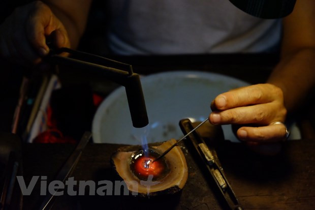 Sin maquinaria moderna, Nguyen Chi Thanh se sienta día tras día en un rincón viejo y polvoriento, y trabaja bajo el calor del fuego y el ruido de los martillos. A pesar de esas condiciones, el amor hacia la joyería tradicional le ayuda a desarrollar su creatividad. El artesano dijo: “Mientras todavía trabajamos a mano, otros artistas utilizan nuevos equipos y tecnología. Al hacerlo, se pueden fabricar muchos productos, pero con un solo diseño. Nosotros, sin embargo, elaboramos las joyas a petición de los clientes, lo que resulta en la diversidad de productos”. Por tal razón, los artículos elaborados por Chi Thanh siempre acapara la atención de los compradores. (Foto: Vietnam+)