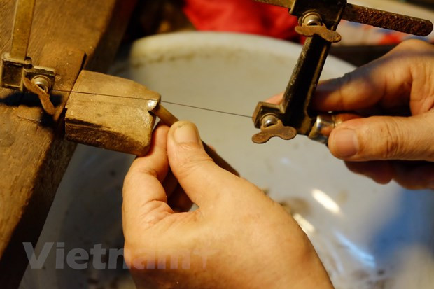 Lo que más atrae a los compradores, especialmente los turistas extranjeros, es la meticulosidad y sofisticación de cada detalle en los productos. Nguyen Chi Thanh dijo que por lo general, los clientes le traen las muestras o dan ideas para que el artesano elabore los artículos de plata según sus preferencias. Los objetos que han sido moldeados serán pulidos. El artista emplea la arena para frotar los objetos de plata, luego los esparce sobre una solución y los calienta sobre la llama. Después de enfriar, se deja reposar el producto en una solución de alumbre hervida, y después se vuelve a alisar con arena y pedazos de vidrio. (Foto: Vietnam+)