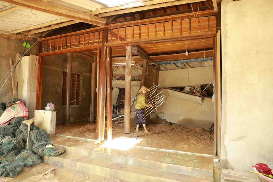 Una mujer limpia los escombros de su casa dañada por el deslizamiento de tierra (Fuente: VNA)