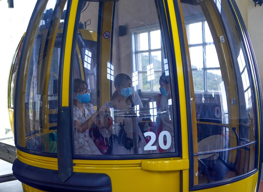 Cada cabina solo transporta la mitad del número máximo de pasajeros, y los visitantes deben usar mascarillas en la zona turística de Ba Na Hills (Foto: VNA)