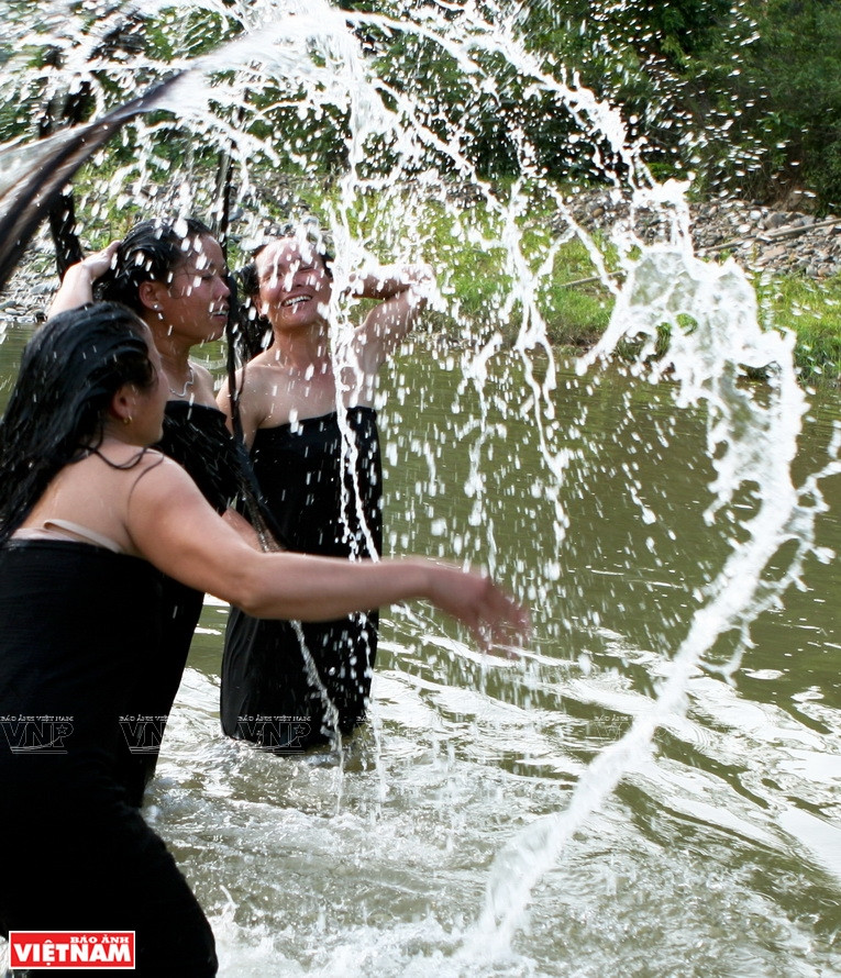 Mujeres de la minoría étnica Thai se relajan en el arroyo Pung Hon (Fuente:VNA)