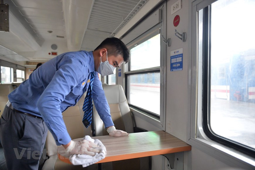 La industria ferroviaria de Vietnam se ha comprometido a cumplir estrictamente con las medidas de prevención de la epidemia y a coordinarse estrechamente con las agencias de salud para frenar la expansión y combatir ese mal en las estaciones y trenes, garantizando así la seguridad de los pasajeros y el personal. El sector ha apoyado activamente el transporte de suministros y equipos médicos a las áreas afectadas por el coronavirus. En la foto, un trabajador limpia la mesa del vagón, como parte de los esfuerzos del sector ferroviario para evitar la expansión del coronavirus y garantizar la seguridad de los pasajeros. (Foto: Viet Hung/Vietnam+)
