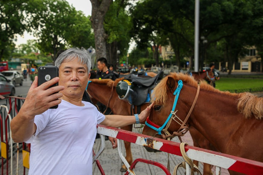 Ya en la madrugada del 8 de junio, un gran número de habitantes de la capital se acercaron al área donde el equipo móvil de la Policía se preparaba para el desfile para tomar fotografías con la caballería. El coronel Nguyen Huy Hanh, jefe de la Fuerza Policial, dijo que la unidad asesoró activamente al Comando de Policía Móvil para organizar el entrenamiento y la formación de bloques para participar en la bienvenida a los líderes del Partido y el Estado. Las fuerzas de seguridad pública están a cargo de coordinar el combate contra la delincuencia, mientras que la guardia fronteriza y el cuerpo aduanero son responsables de prevenir el tráfico de drogas en las zonas limítrofes y los puertos, por lo que no deben realizar esta tarea por separado, señaló. (Foto: Vietnam+)
