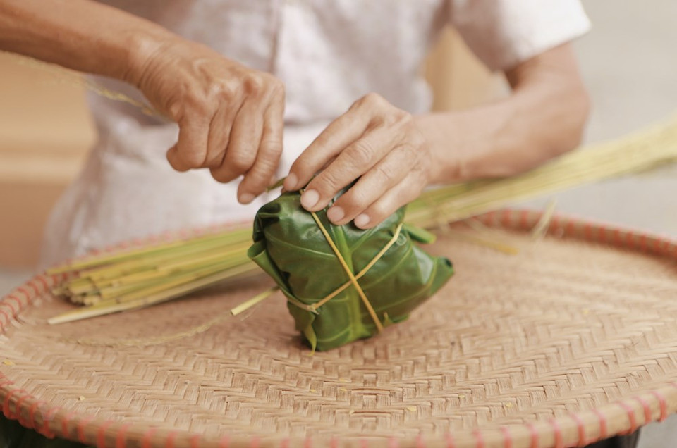 Com (arroz glutinoso tierno) con coco rallado y frijoles verdes deviene una especialidad de Hanoi, la capital de Vietnam, en el otoño. Dos temporadas resultan las ideales para producir “Com”: abril y agosto del calendario lunar. El mes de agosto lunar deviene el mejor momento para preparar este producto. Se recolecta cuando todavía está verde y, posteriormente, se aplasta ligeramente y se seca. El producto está envuelto entre superpuestas hojas de plátano y de loto, unidas por tiras de bambú. Se preparan muchos platos como empanado de arroz verde y dulce, y en especial, arroz cocido al vapor, que tiene un sabor dulce y color atractivo. (Foto: Vietnam+)