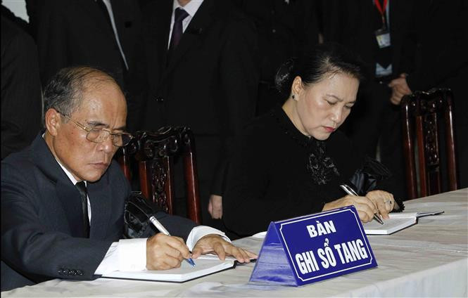La presidenta de la Asamblea Nacional de Vietnam, Nguyen Thi Kim Ngan, y su predecesor Nguyen Sinh Hung escriben en el libro de condolencias por el deceso del presidente Tran Dai Quang (Fuente: VNA)
