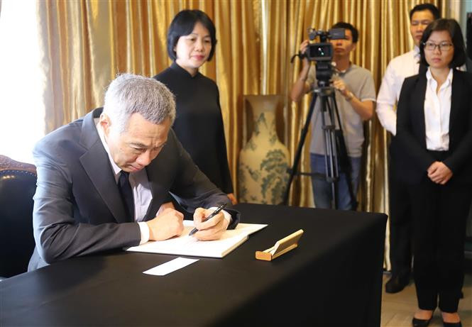 El primer ministro de Singapur, Lee Hsien Loong, escribe en el libro de condolencias dedicado al presidente de Vietnam, Tran Dai Quang (Fuente: VNA)