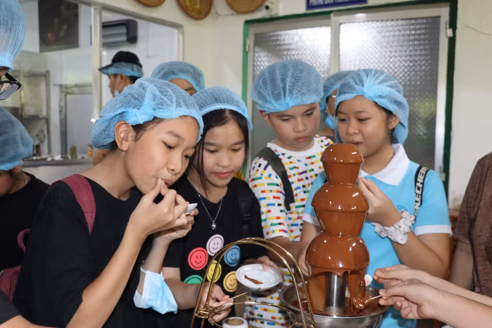 Visitantes disfrutan del chocolate fresco producido en la fábrica. Foto: VNA