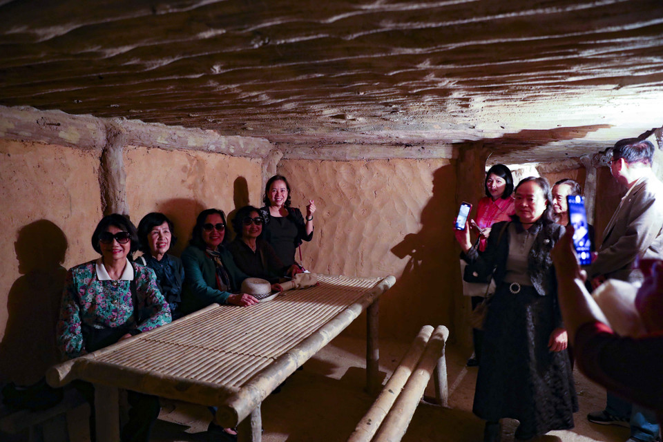 Turistas visitan y toman fotografías de recuerdo en el sótano de trabajo del General Vo Nguyen Giap en las reliquias del cuartel general del Comando de Campaña de Dien Bien Phu. Foto: VNA