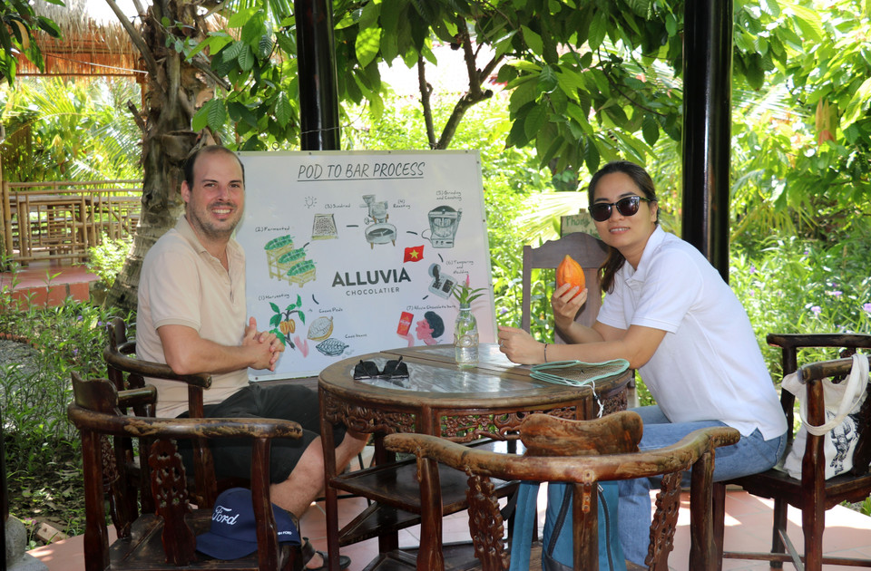 Turistas extranjeros visitan el huerto de cacao y la fábrica de chocolate. Foto: VNA
