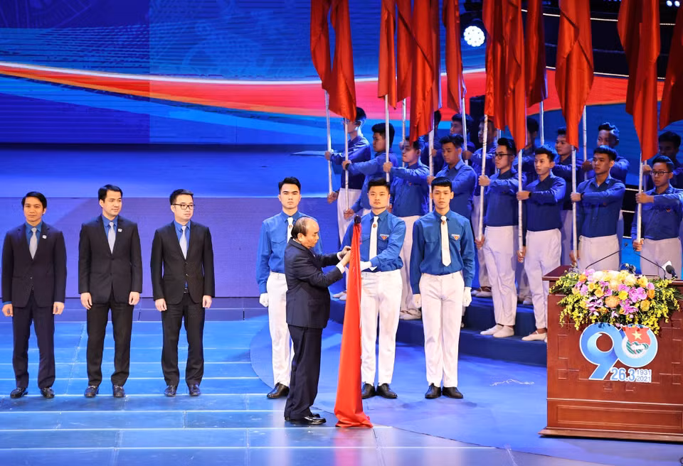 El secretario general del PCV y presidente, Nguyen Phu Trong; el primer ministro, Nguyen Xuan Phuc, y los delegados realizan la ceremonia de izamiento de la bandera. (Foto: VNA)