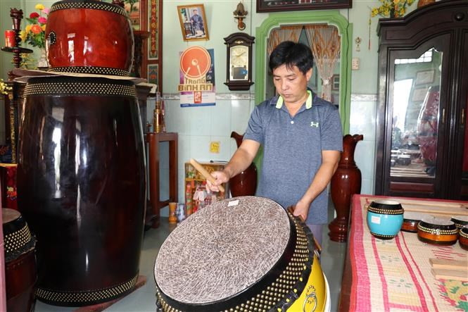 Un fabricante de tambores, Nguyen Van An, verifica los sonidos de cada tambor antes de entregarlos a los clientes. (Foto: VNA)