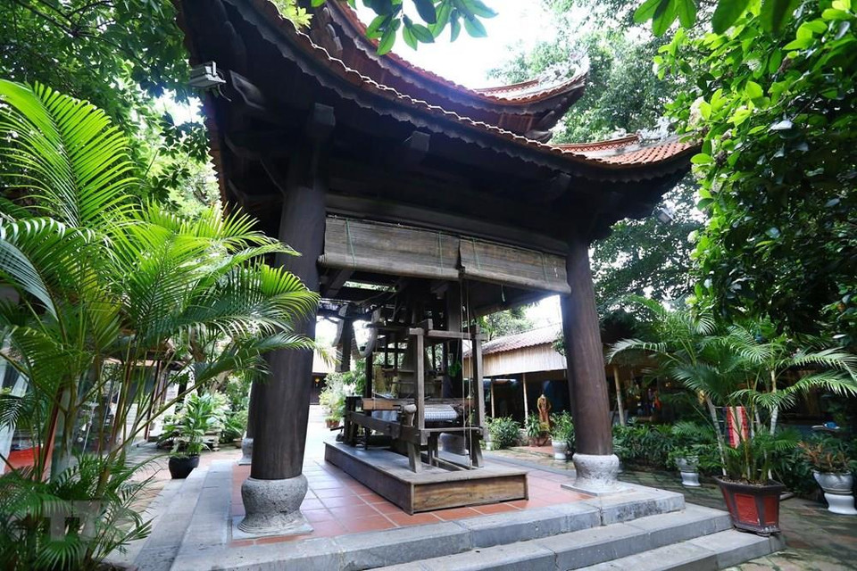 Antigua máquina de confeccionar telas de seda en frente del templo. (Foto: VNA)