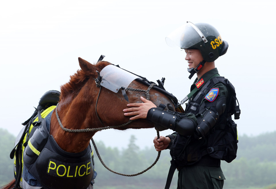 El sargento Nguyen Phuong Nam con su "amigo" llamado Lucky después del entrenamiento. (Fuente:VNA)
