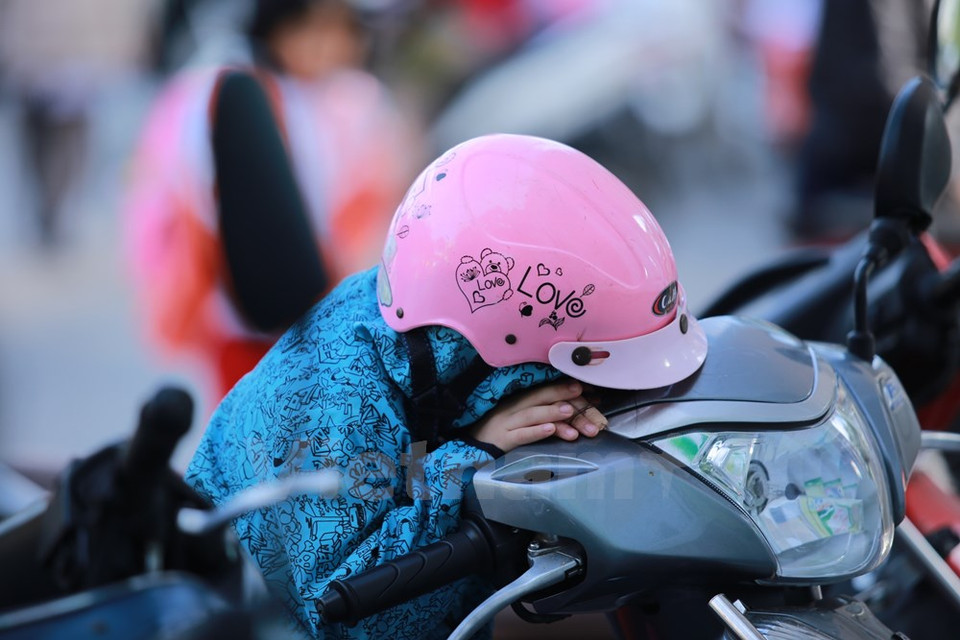 Niño duerme cuando espera a su madre que está comprando desayuno.