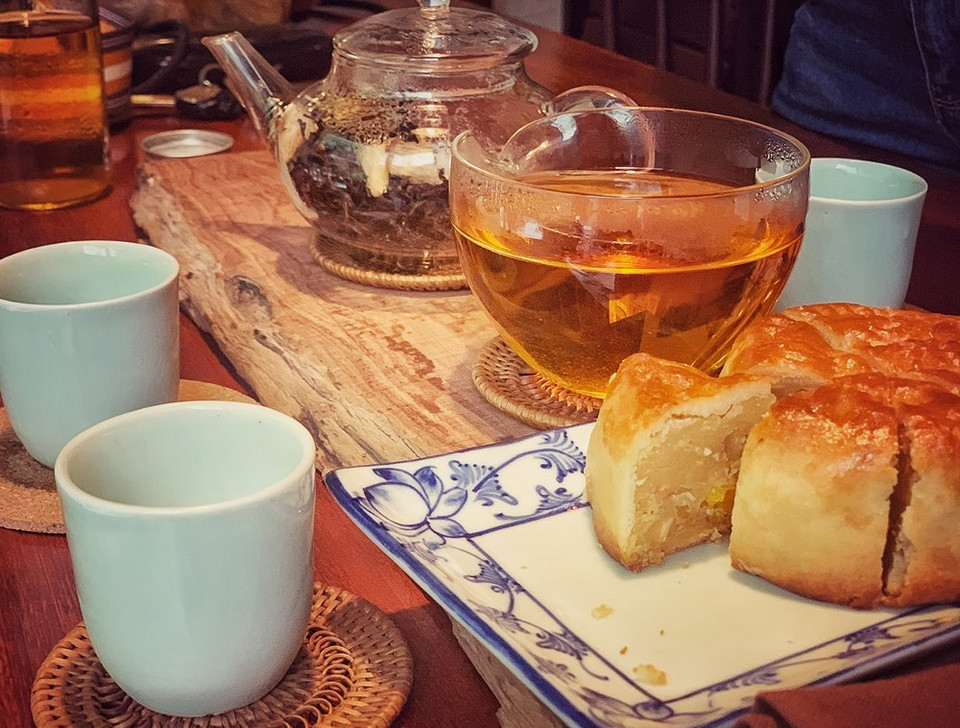 Definitivamente, no olvides disfrutar del té con un trozo de pastel de luna. Se trata de un pastel pequeño y redondo con relleno dulce o salado. Hay muchas variaciones diferentes del pastel de luna, dependiendo de dónde seas en Asia; el único elemento común es el simbolismo de la luna. Algunas panaderías rellenan hasta cuatro yemas de huevo saladas en un solo pastel de luna, porque cuantas más lunas tengas, más abundante será la recompensa para el consumidor. También verá pasta de frijoles rojos, pasta de sésamo y una mezcla de cinco semillas en algunos pasteles de luna, aunque no son tan fáciles de encontrar. El té se prepara sumergiendo flores de crisantemo secas en agua caliente. (Foto: Mai Mai/Vietnam+)