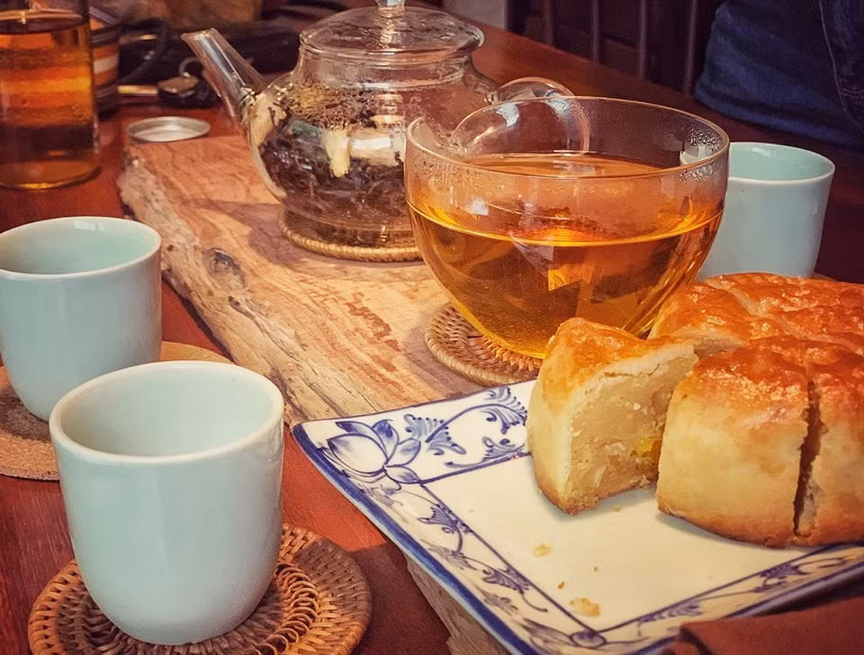 Definitivamente, no olvides disfrutar del té con un trozo de pastel de luna. Se trata de un pastel pequeño y redondo con relleno dulce o salado. Hay muchas variaciones diferentes del pastel de luna, dependiendo de dónde seas en Asia; el único elemento común es el simbolismo de la luna. Algunas panaderías rellenan hasta cuatro yemas de huevo saladas en un solo pastel de luna, porque cuantas más lunas tengas, más abundante será la recompensa para el consumidor. También verá pasta de frijoles rojos, pasta de sésamo y una mezcla de cinco semillas en algunos pasteles de luna, aunque no son tan fáciles de encontrar. El té se prepara sumergiendo flores de crisantemo secas en agua caliente. (Foto: Mai Mai/Vietnam+)