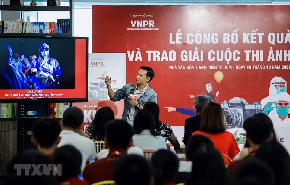 El reportero Luu Trong Dat de la VNA presenta la obra ganadora de la categoría “Foto captada con cámaras profesionales” en el concurso “Vietnam resiliente”. El certamen difunde imágenes sobre el pueblo vietnamita en la lucha contra la pandemia. (Foto: VNA)