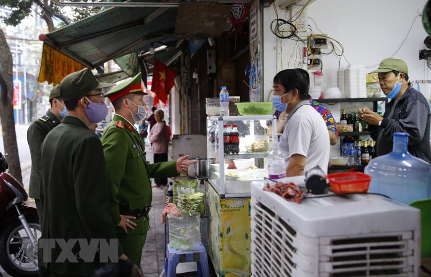 La policía del barrio de Hang Ma supervisa la implementación del cierre de los puestos de venta de comida, té y café (Foto: VNA)