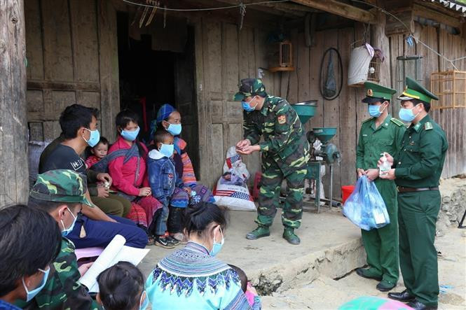 Oficiales del puesto de control fronterizo Pha Long, de la guardia fronteriza de la provincia norteña de Lao Cai, divulgan las medidas preventivas del coronavirus entre los pobladores de las etnias minoritarias. (Foto: VNA)