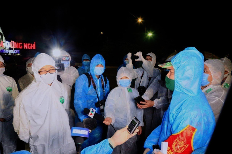 Reporteros cubren la visita de inspección del viceprimer ministro Vu Duc Dam sobre la prevención y lucha contra el COVID-19 en la comuna de Dong Trieu, Quang Ninh. (Foto: VNA)