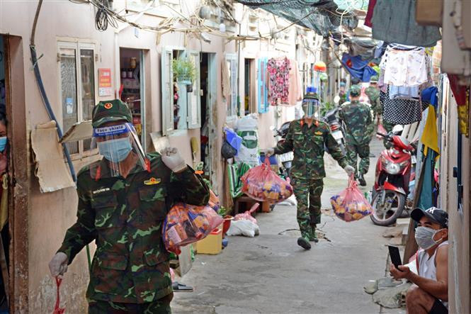 Los oficiales y soldados del Regimiento 31, División 309, entregan obsequios a personas en las áreas epidémicas en el barrio 16, distrito 8, Ciudad Ho Chi Minh. (Foto: VNA)