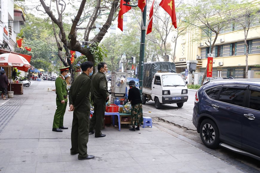 La policía del barrio de Cua Nam supervisa la implementación del cierre de los puestos de venta de comida, té y café en las aceras (Foto: VNA)