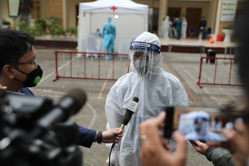 Representante del grupo de trabajo en un puesto de prueba rápida del coronavirus en el bachillerato Dong Da en Hanoi, responde a la prensa el 31 de marzo de 2020. (Foto: VNA)