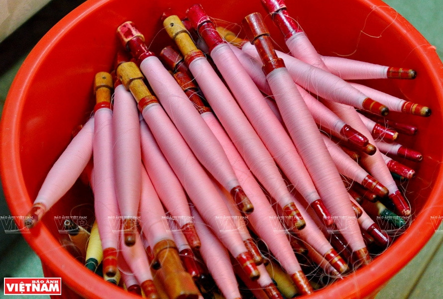 Rollo de seda rosa utilizado para tejer telas.