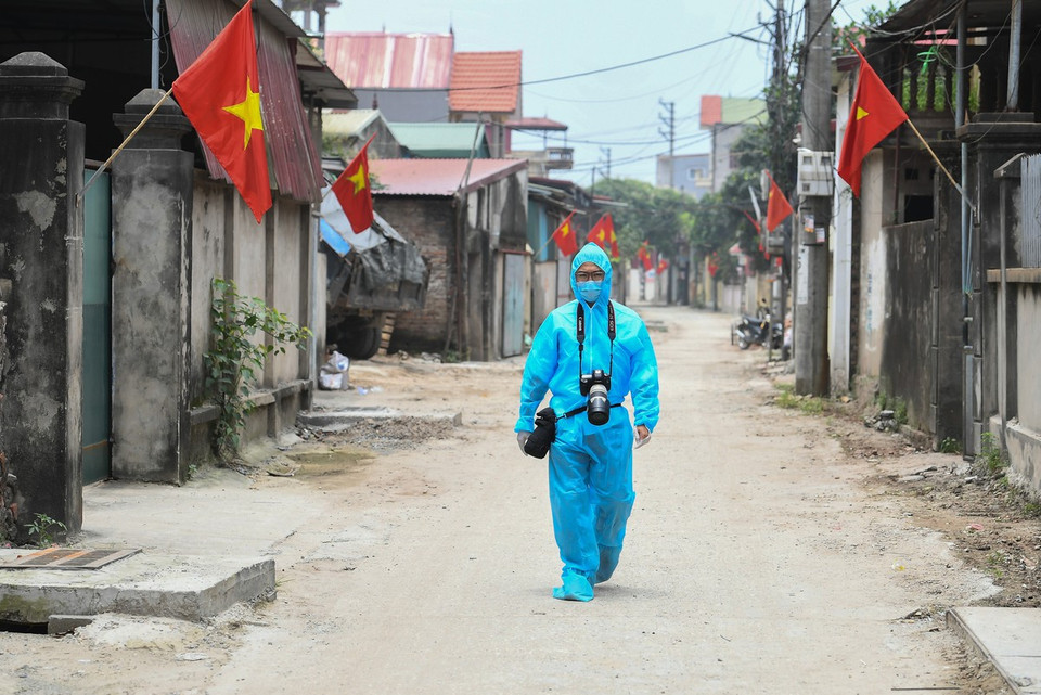El reportero Thanh Dat de la VNA trabaja en la zona epidémica en la aldea de Lo Giao, distrito de Dong An, Hanoi. (Foto: VNA)