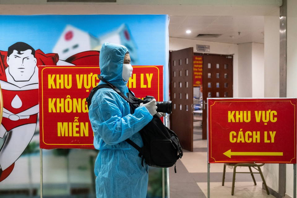 El reportero Minh Quyet, del Departamento de Fotografía de la VNA trabaja en la zona de cuarentena en el Instituto Central de Hematología y Transfusión de Sangre. (Foto: VNA)