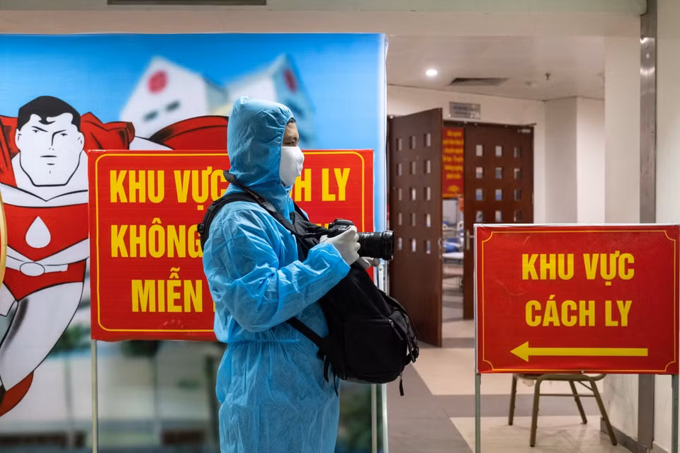 El reportero Minh Quyet, del Departamento de Fotografía de la VNA trabaja en la zona de cuarentena en el Instituto Central de Hematología y Transfusión de Sangre. (Foto: VNA)