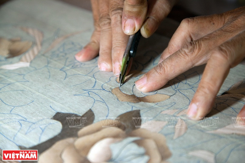 Etapa de utilización de un cuchillo para cortar los pequeño detalles después de dibujar la pintura (Fuente: VNA)