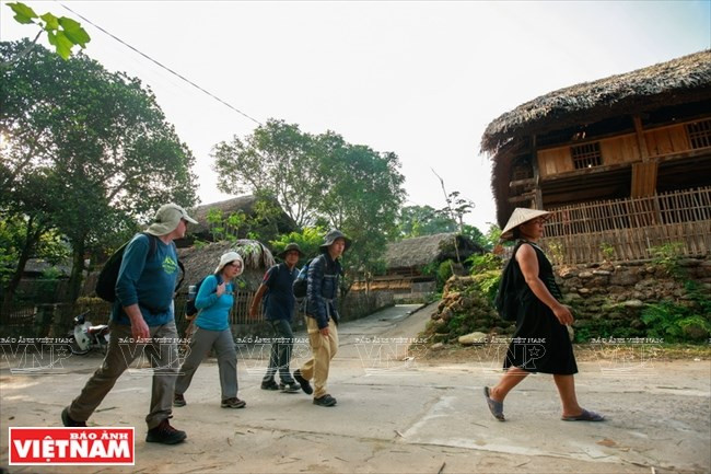 Turistas extranjeros visitan la aldea Ha Thanh (Fuente: VNA)
