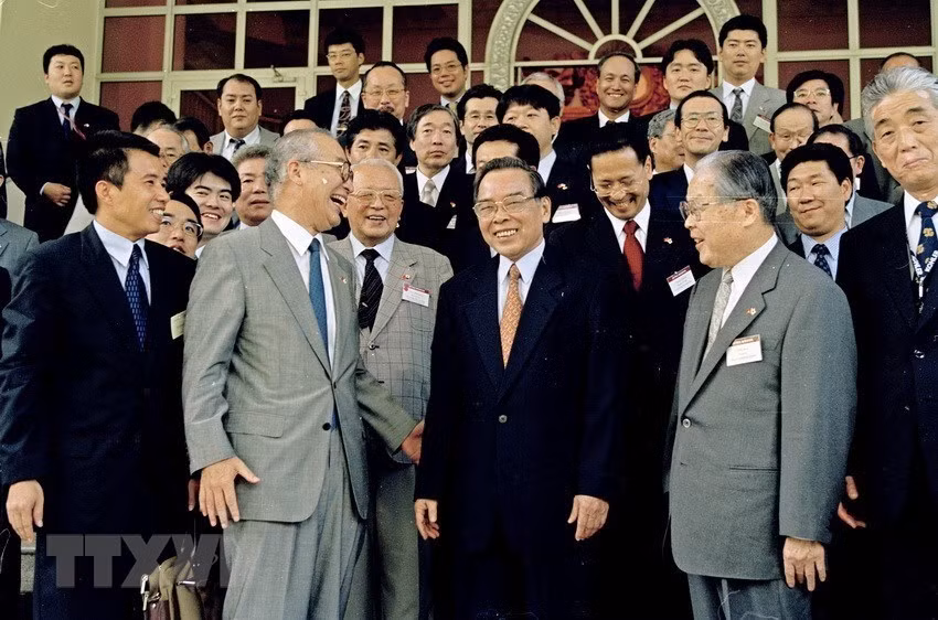 El Primer Ministro Phan Van Khai (centro, en traje negro) y una delegación de la Organización de Comercio Exterior de Japón (JETRO) dirigida por el Presidente y director ejecutivo Osamu Watanabe, en Hanoi el 4 de agosto de 2003. (Foto: VNA)