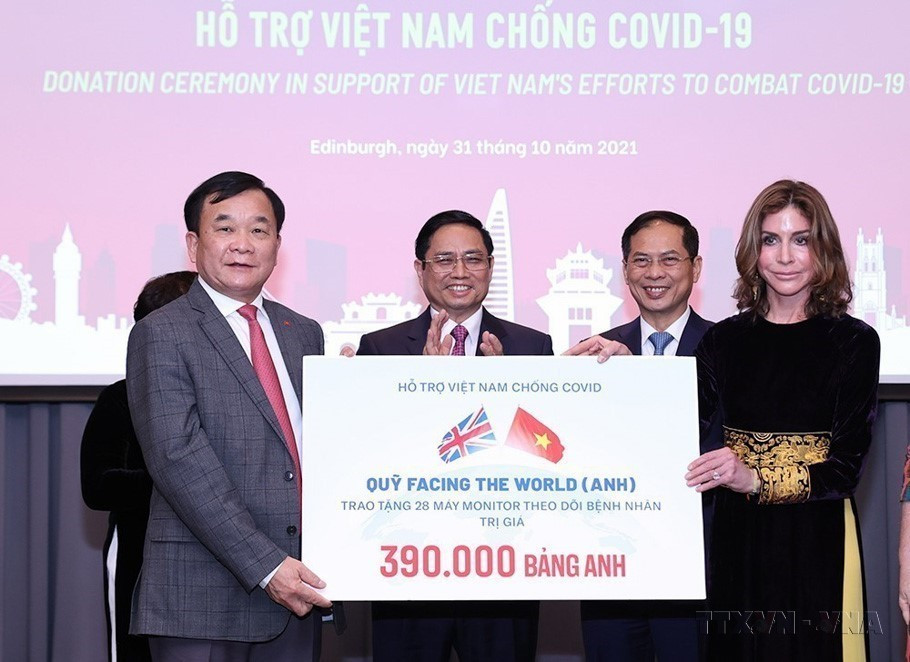 El primer ministro Pham Minh Chinh presenció la entrega de donaciones para apoyar a Vietnam en la lucha contra la pandemia de COVID-19 durante su visita de trabajo a Reino Unido (2021). Foto: VNA