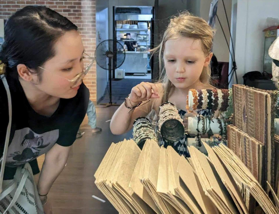 Cuc Huong presenta productos de papel tradicional vietnamita hecho a mano a los niños. Foto: Revista Vietnam