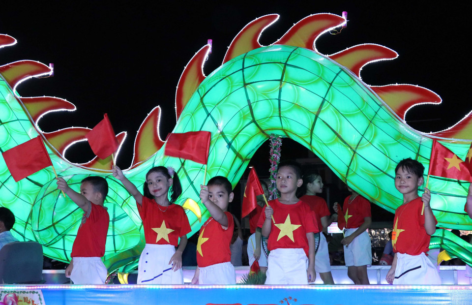 Los niños disfrutan de los modelos gigantes de linternas del Festival del Medio Otoño que desfilan por las calles de Tuyen Quang. Foto: VNA