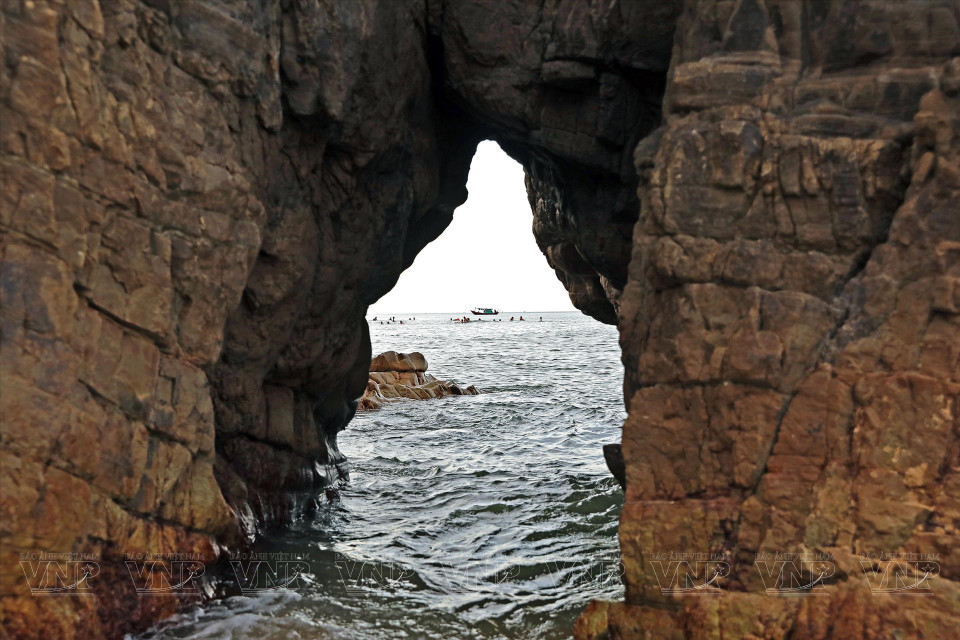 La playa tiene grietas en las rocas erosionadas por las olas del mar que forman pequeñas cuevas.