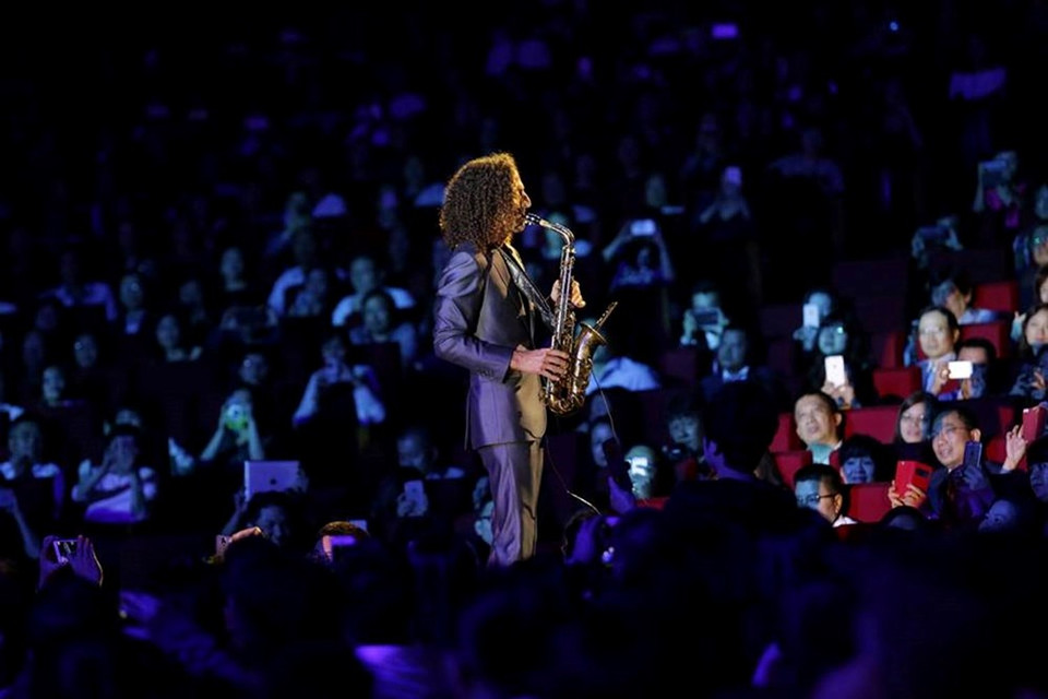 Kenny G aparece en medio de la audiencia, con el célebre saxófono.
