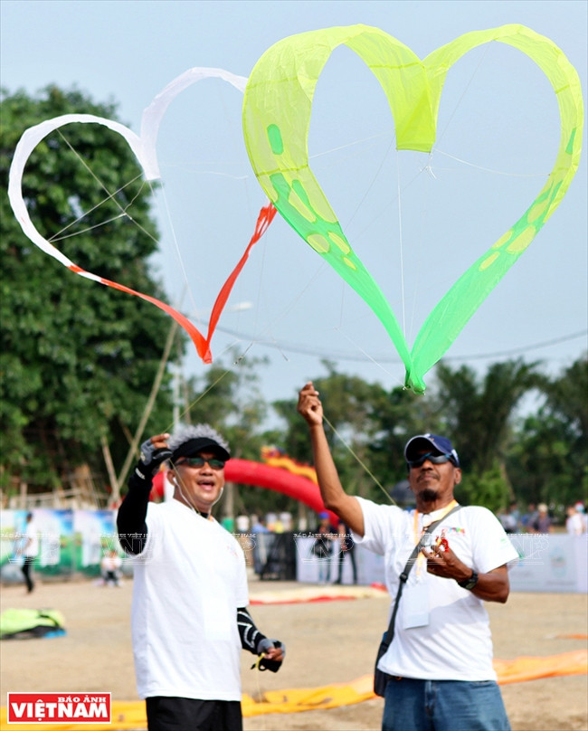 Artistas singapurenses con el papalote "Doble corazón". Es difícil controlar este tipo.