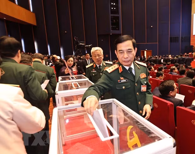 El miembro del Comité Central del PCV, permanente de su Comisión Militar, jefe del Estado Mayor General y también viceministro de Defensa, coronel general Phan Van Giang, y los delegados votan por el Comité Central del XIII mandato (Fuente:VNA)