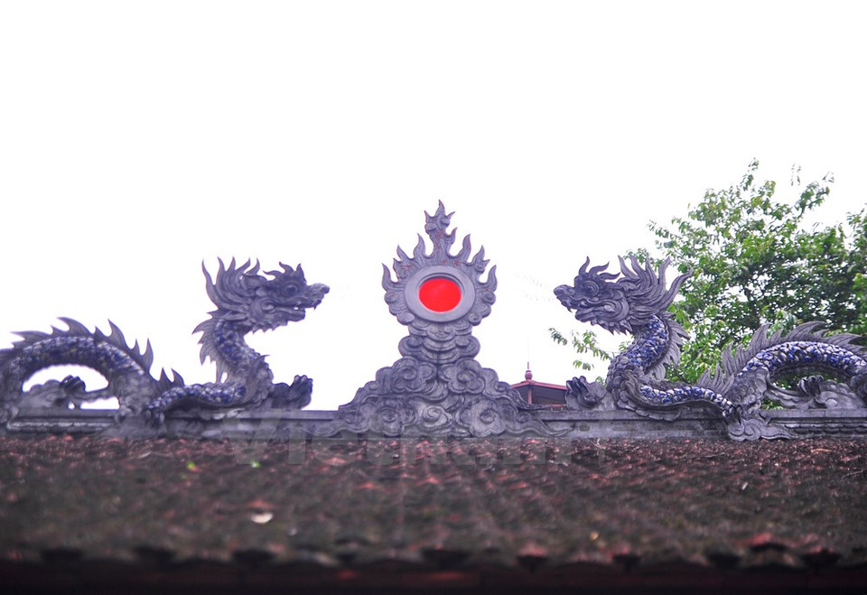 Grabados en piedra colocados en el techo: un par de dragones se tornan hacia la figura del sol