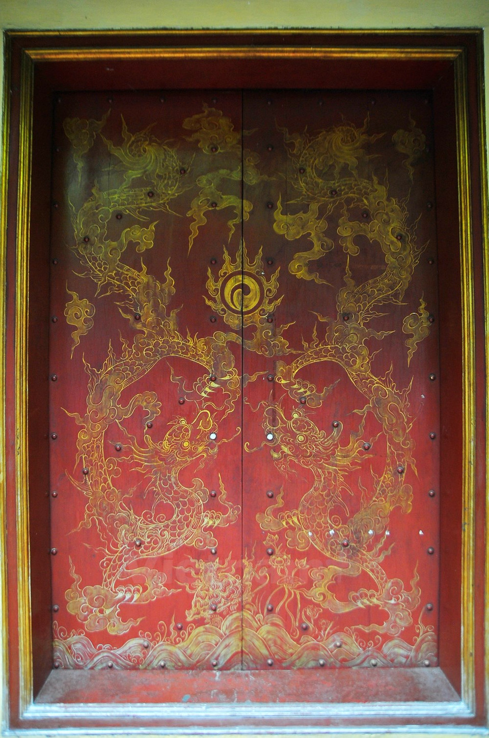 Puerta roja decorada con dragón dorado – un motivo ornamental típico.