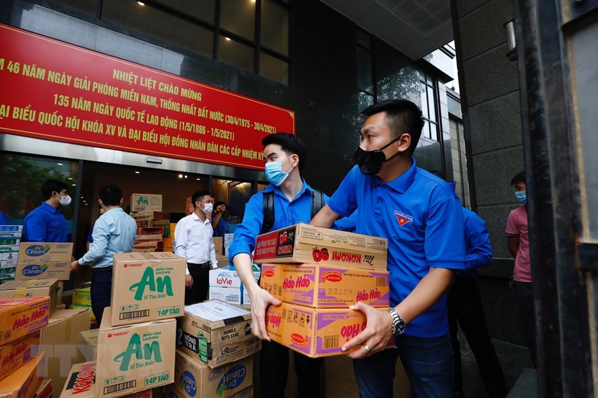 Los miembros de la UJCHCM y jóvenes del bloque de órganos centrales participantes en el transporte de productos de primera necesidad para apoyar a la provincia de Bac Giang en la lucha contra el COVID-19 (Foto: VNA)