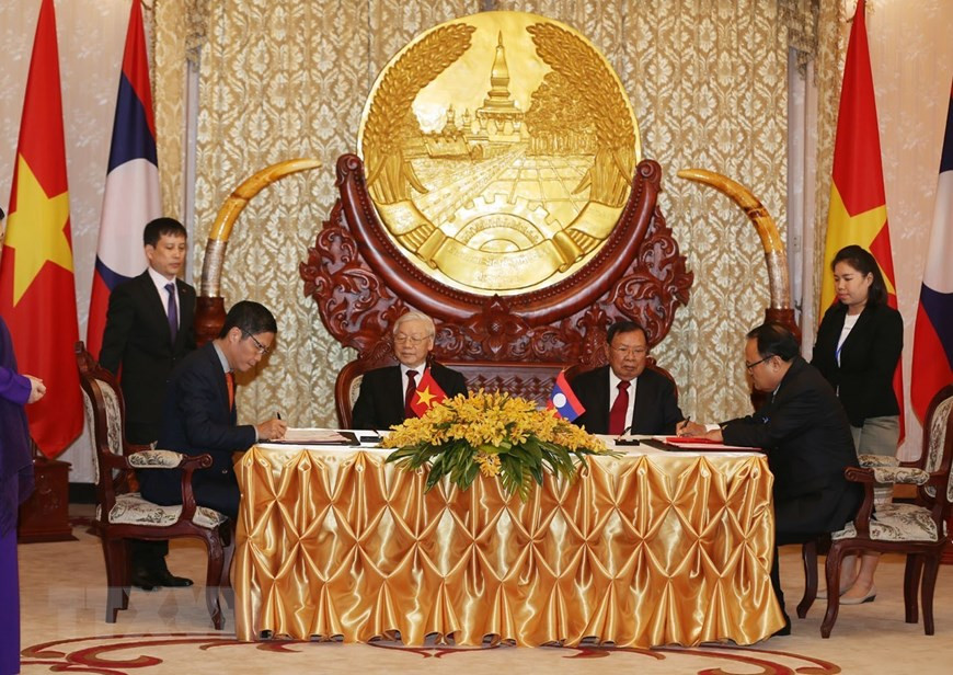 El secretario general del Partido Comunista y presidente de Vietnam, Nguyen Phu Trong, y el secretario general del Partido Popular Revolucionario y presidente de Laos, Bounnhang Vorachith, asistieron a la firma del acuerdo de cooperación bilateral en el desarrollo de los proyectos de energía eléctrica y minerales. (Fuente: VNA)